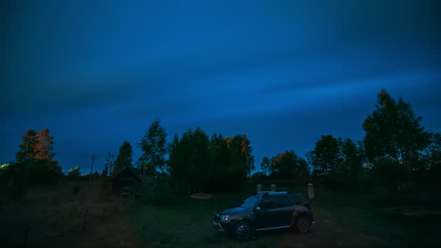 Blue Starry Sky Background Time Lapse. Bright Night Dramatic Sky With Star Trails Above Suv Car At Countryside. Bold Blue Timelapse Night Starry Sky. Summer Early Night