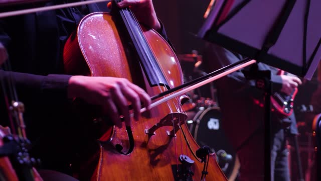 A man plays the cello at a concert.