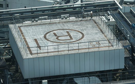 The letter R for emergency rescue space in a helicopter written on the roof of a high-rise building