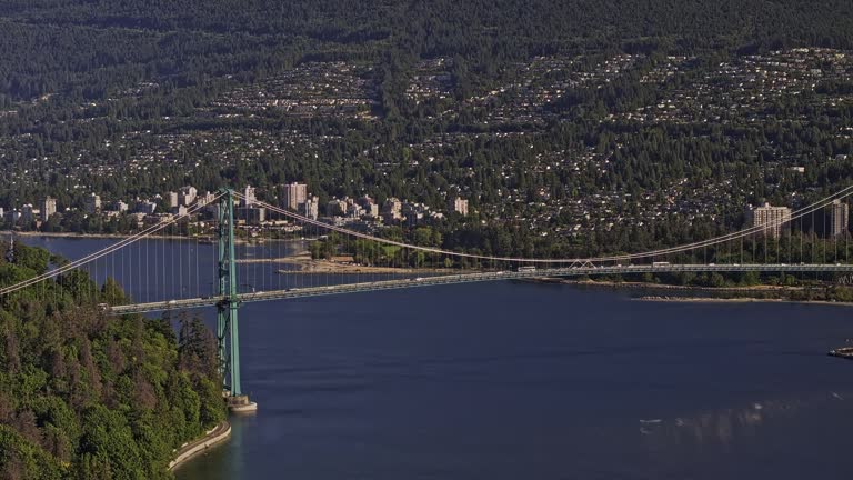 Vancouver BC Canada Aerial v77 flyover capturing traffic on Lions Gate Bridge linking Stanley Park and North shore over Burrard inlet and West mountain views - Shot with Mavic 3 Pro Cine - July 2023