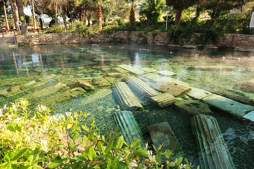 The picturesque Cleopatra Pool, hot spring with submerged roman columns inside in the early morning, Denizli, Turkey 2022