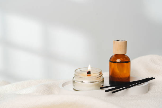 Elegant Aroma Diffuser With Reed Sticks And Scented Candle On White Tablecloth