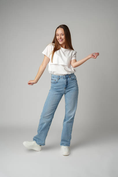 istock Young smiling girl dancing having fun on gray background 2101269977
