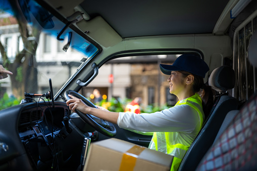 Female driving in the vehicle on the way to delivery parcels