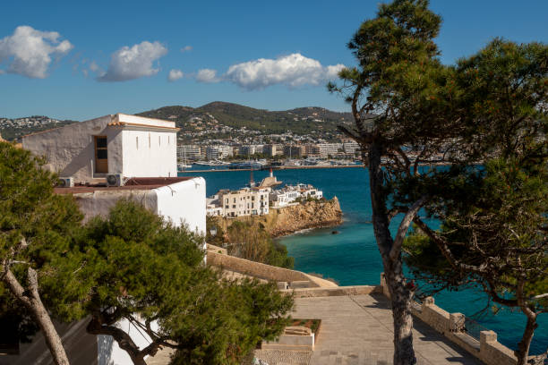 View of Ibiza old town white houses hanging on the cliff and the city new buildings on the background, Ibiza Island, Balearic Islands, Spain
