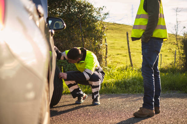 istock Mechanic examining a broken car in a rural road 2101283241