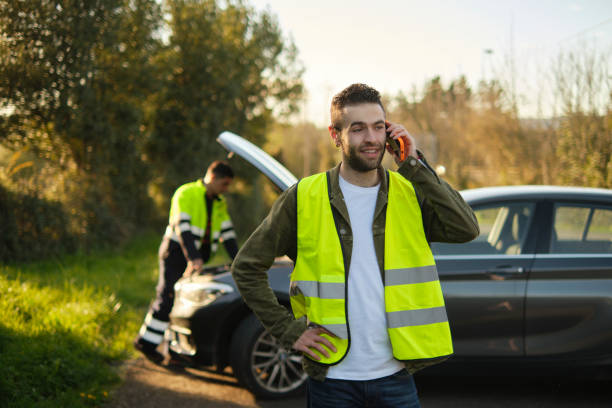 Latin American tow truck operator towing a car and feeling sorry for the owner - roadside assistance concepts