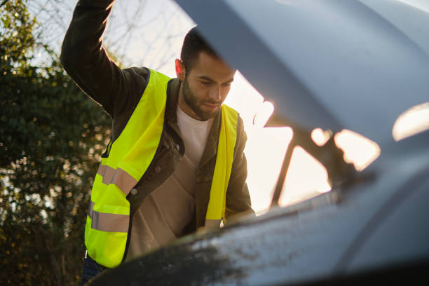 istock Man looking at the engine of a broken car 2101283259