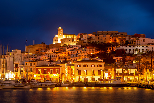 View of Ibiza old town at night, with the nightlights reflected on the harbor, Ibiza Island, Balearic Islands, Spain