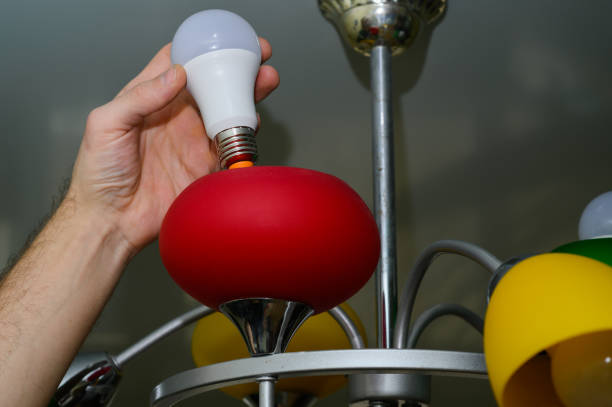 istock replacing the light bulb in the chandelier. LED lamp. 2101289038