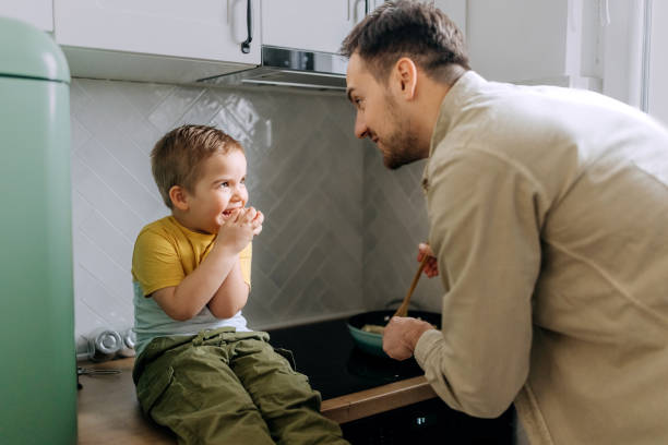 istock Father and son having fun while making pasta together in a domestic kitchen 2101296981