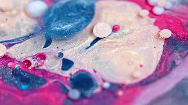 Close-up of vibrant ink drops in water with swirling patterns and abstract shapes