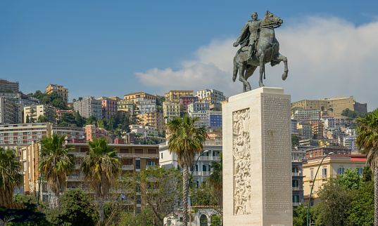 Cityscape of coastal Naples, Italy, with Armando Diaz monument in Villa Comunale public gardens. The sculpture was erected in 1936 and is attributed to artist Nagni Francesco.