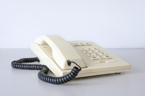Desk phone 80s, 90s. Push-button dialing. White. Isolated on white table