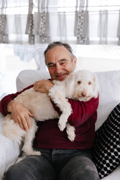 istock White old man loves his dog while sitting on the couch 2101328604