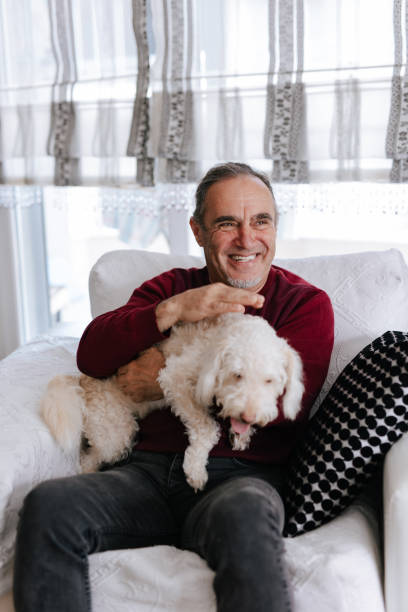 istock White old man loves his dog while sitting on the couch 2101331925