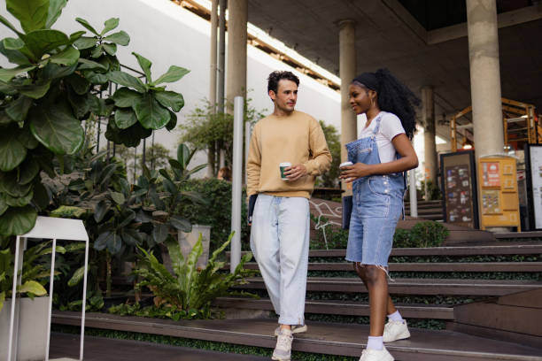 istock Diverse couple of students talking on the move at staircase. 2101337412