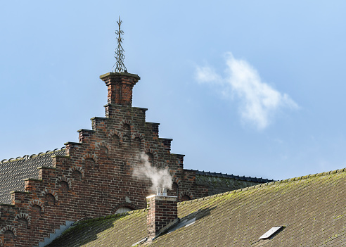 Fireplace heating in old buildings in Europe. Exterior view of the roof with chimney