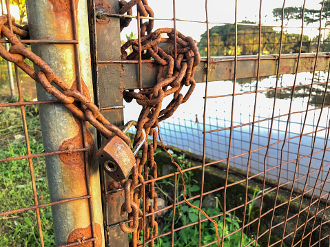 The garden gate was locked with a rusty padlock and chains