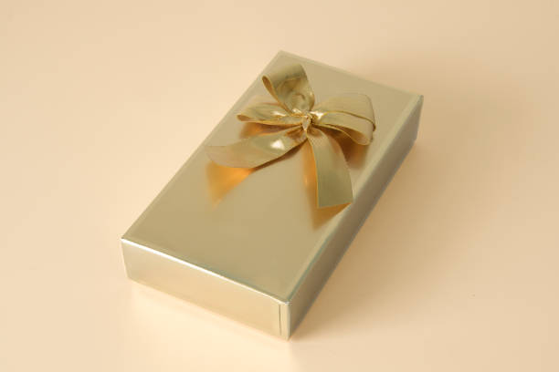 istock Classic gift wrapping in gold style with an elegant bow, copy space, mockup 2101373074