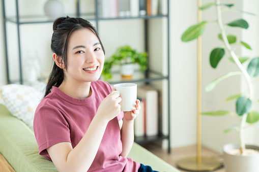 Young Japanese woman drinking coffee in the living room