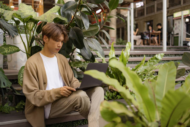istock Asian male student e-learning over laptop at campus. 2101396310