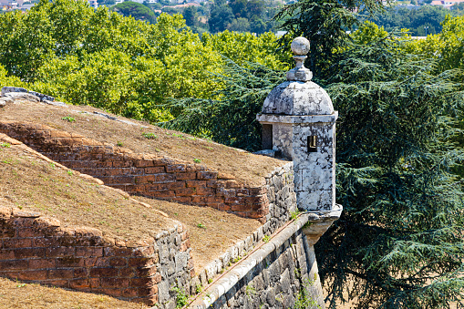 A section of the old Valença Fortress wall with a white guard watchtower, green trees. Portuguese border with Spain through Galicia. Valença, Portugal.