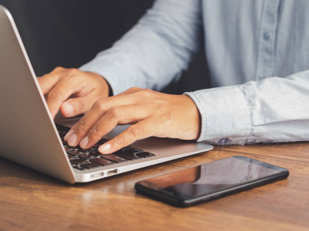 istock Young man working with a laptop while sitting at a desk in the office. 2101424530