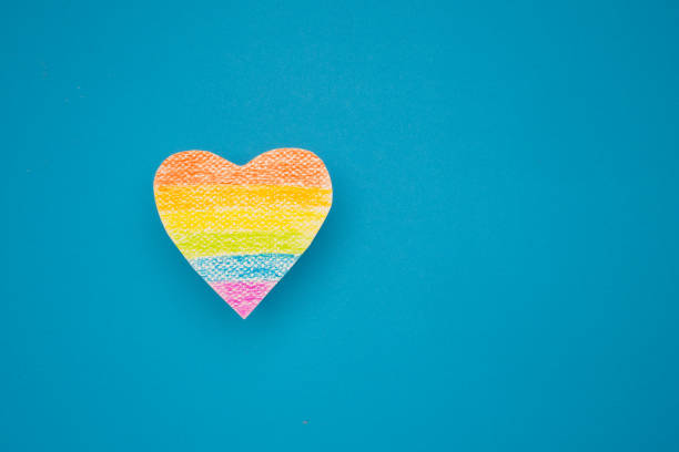 A rainbow heart made from paper on a blue background. Space of text. Gender diversity concept