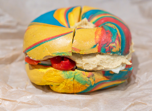 Multi colored rainbow vegetarian bagel .