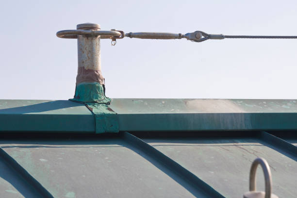 istock Horizontal lifeline fall protection system with inox stainless steel cable on copper roof used to prevent the danger of falling - buildings and safely access all areas of a rooftop 2101457637