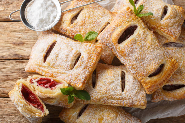 istock Sweet berry puff pastry with powdered sugar and mint close-up. Horizontal top view 2101465766