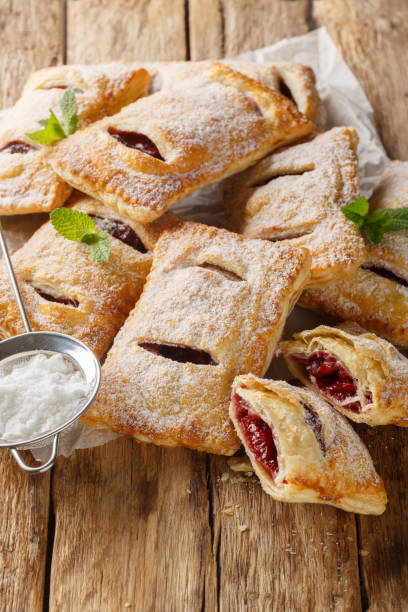 istock Cherry puff pastry with powdered sugar and mint close-up. Vertical 2101466908