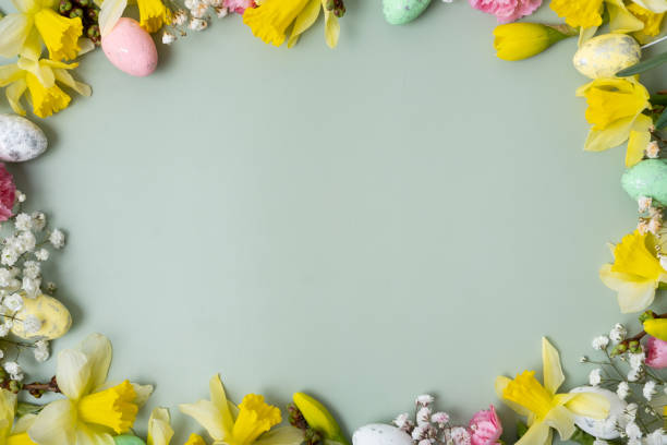 istock Spring flowers ans easter eggs border on green background with copy space. Easter greeting card 2101467439