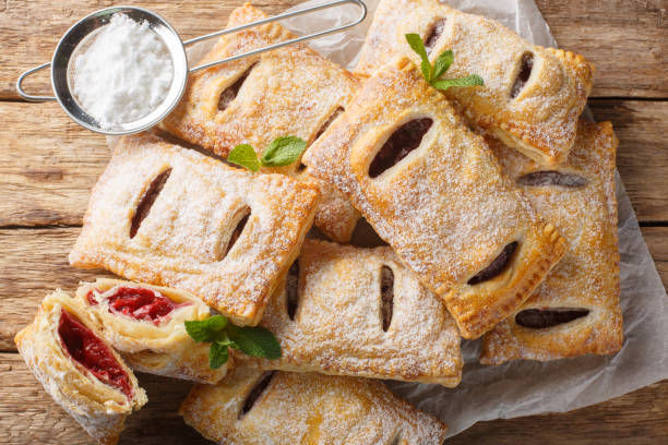 istock Baked puff cherry pies with powdered sugar and mint close-up. Horizontal top view 2101474989