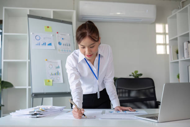 istock A businesswoman with determination takes note, write work plan and graphs the company's financial schedule in her office. 2101478813