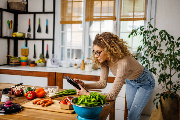 istock Beautiful lady using digital tablet to find ideas for diner 2101480506