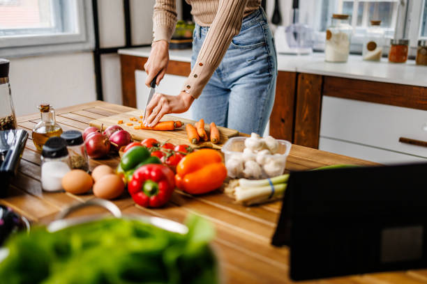 istock Hands of young woman while chopping vegetables 2101482119