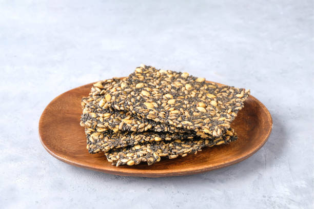 istock Seed crackers on wooden plate background with copy space 2101521760