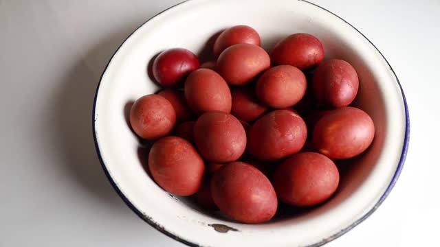 A large bowl of Easter red eggs, placed on a table, with a copyspace.