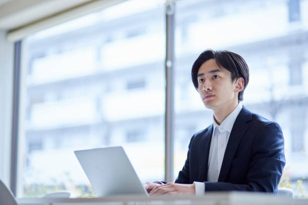 istock A young Japanese businessman in a suit working on a computer in the office 2101583665