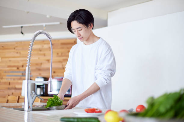 istock Young Japanese man cooking in the kitchen 2101585232