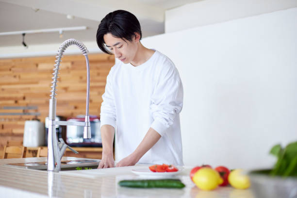istock Young Japanese man cooking in the kitchen 2101585643