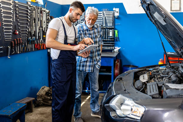 istock An Auto Mechanic is Repairing a Car Explaining Car Problems to a Senior Customer. 2101588896