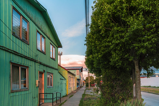 street view on typical houses in puerto natales at sunset hour under moody sky