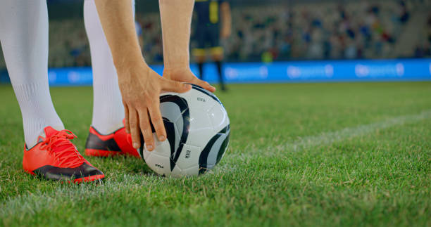 istock Football player adjusting ball 2101640008