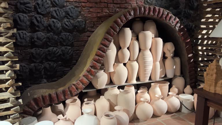 Pottery in the workshop of the master are on the shelves and risers cookware in varying sizes. displayed on an old. wooden table at a market in the Georgian Republic. Video DCI 4k