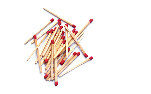 Pile of matches wooden sticks with red sulfur, scattered on white background. Concept, tool or equipment used for igniting fire made from small wooden sticks. with flammable substance on one end.