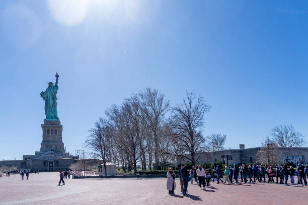 Liberty Island, New York, USA - March, 2024.  Statue of Liberty on Liberty island with tourists in the foreground near the Statue of Liberty museum.