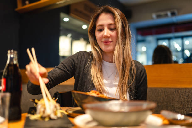 istock Young woman going out to eat sushi for dinner 2101668309